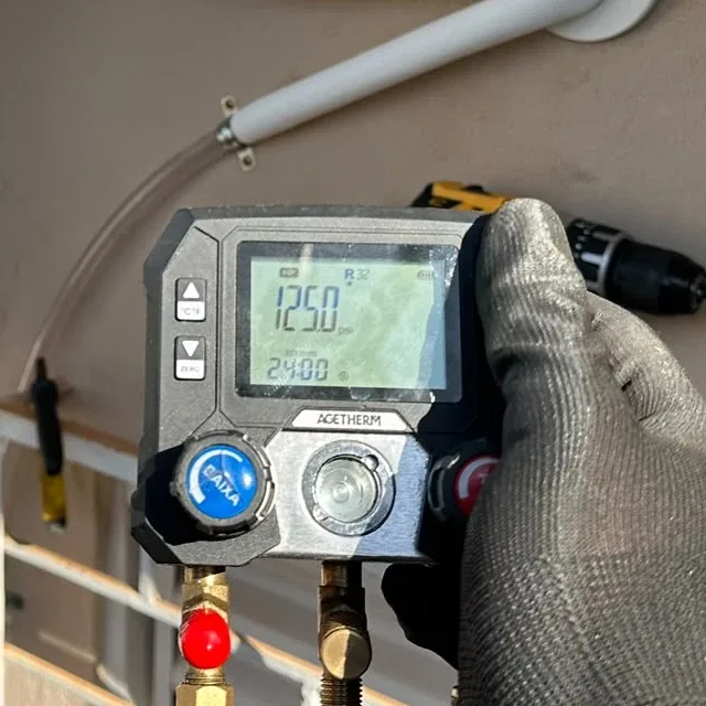 Manômetro digital marcando 125 psi no lado de baixa, com gás R32
